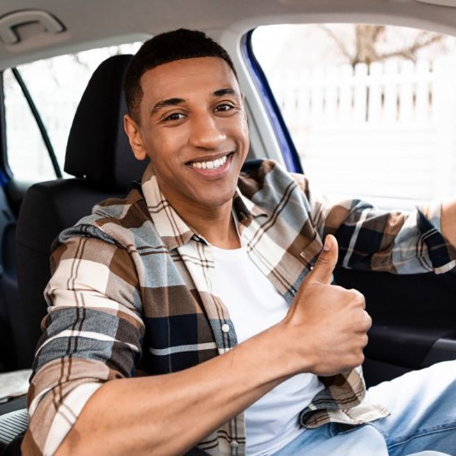 Man smiles in car