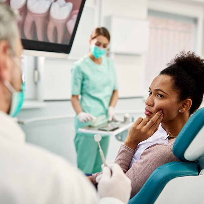 Patient with toothache talking to dentist at appointment
