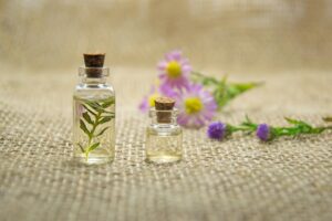 Small jars of essential oils and flowers