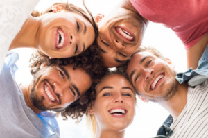 Group of friends looking down and smiling with brilliant teeth